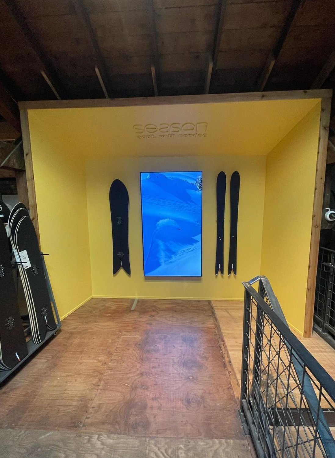 Elegant Black Season Skis on Bold Yellow Wall: Modern Storage Artistry