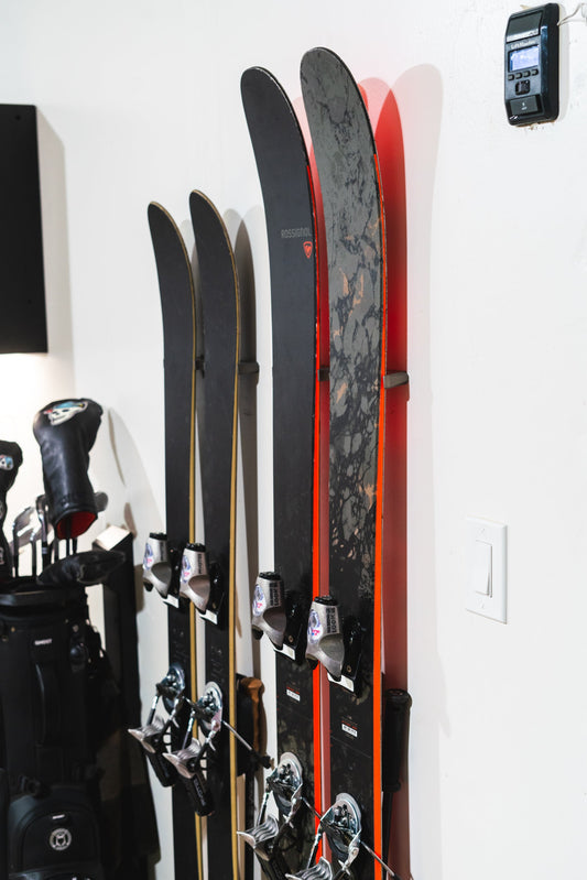 Sleek Black and Red Rossignol Skis on Minimalist White Wall Display