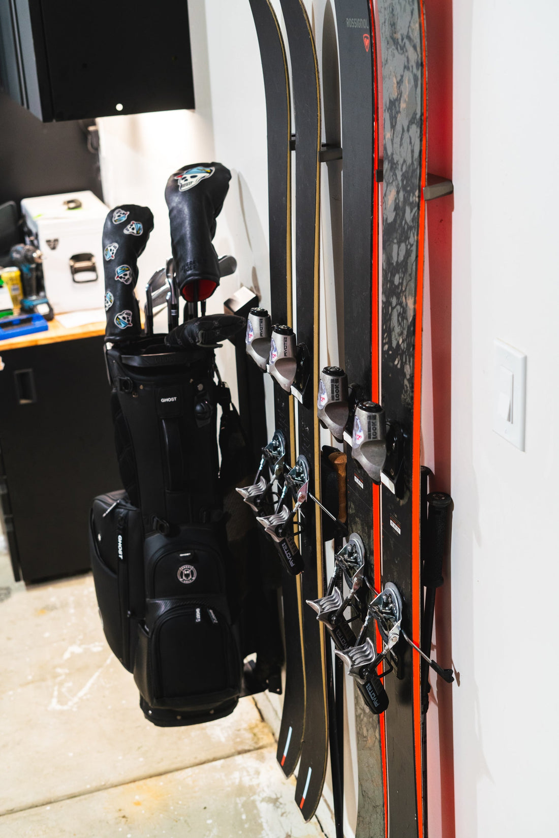Rossignol Black and Red Skis on White Wall: Sleek Storage Elegance