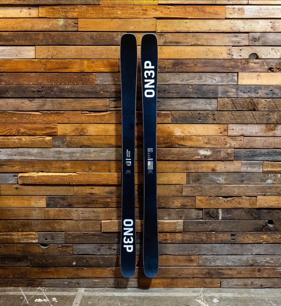 Black ON3P Skis on Rustic Wood Wall: A Fusion of Elegance and Functionality
