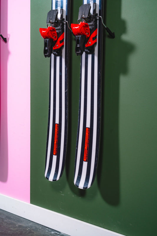 Bold Black and White Striped Skis on Modern Green and Pink Wall Display