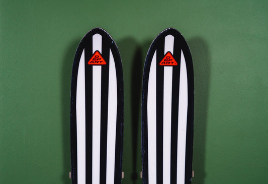 Black and White Striped Skis on Green Wall: A Modern Storage Statement