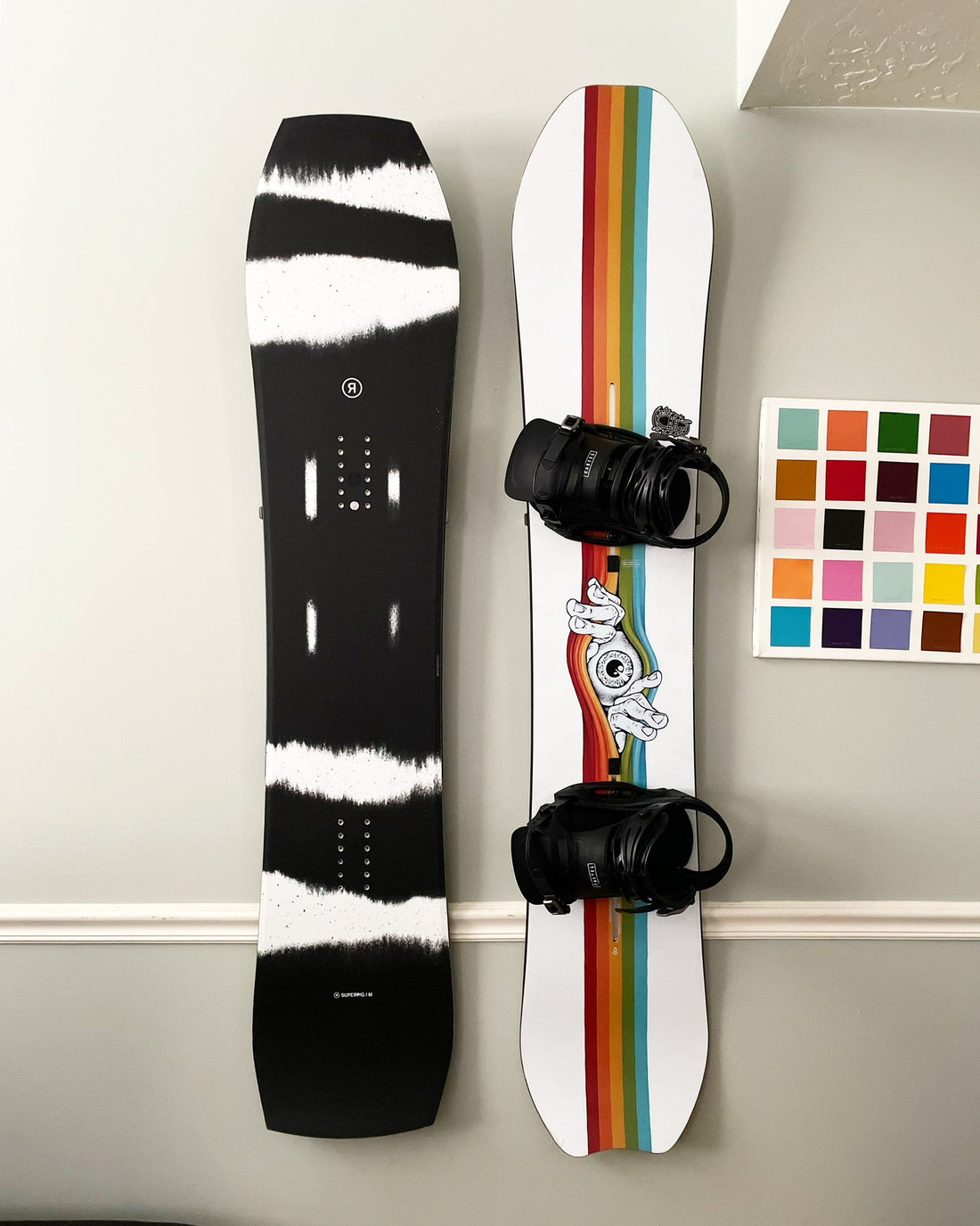 Monochrome Waves and Rainbow Streaks: Snowboards on Sleek Gray Wall