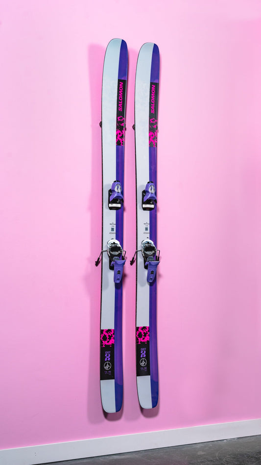 Vibrant Salomon Skis with Purple Accents on Chic Pink Wall Display
