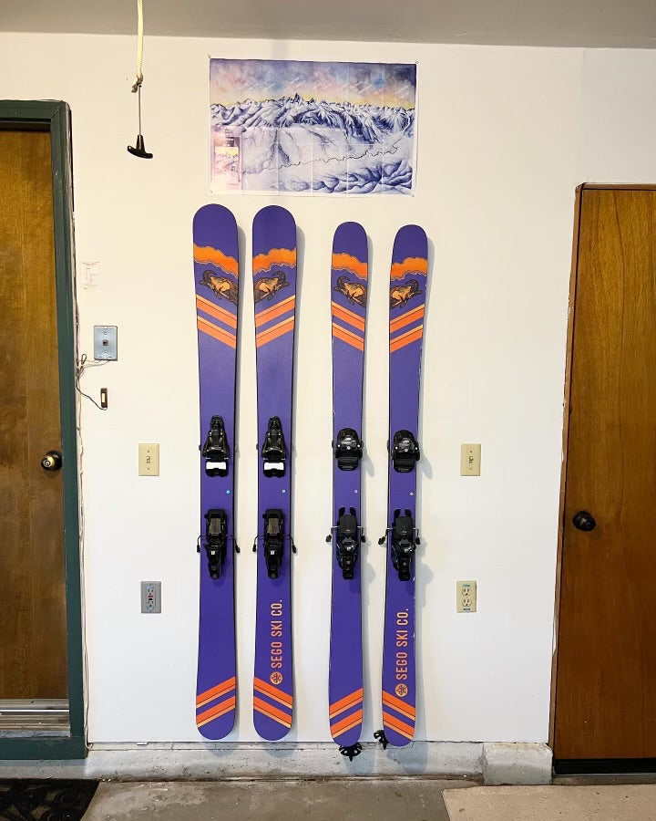 Vibrant Sego Purple and Orange Skis on Sleek White Wall: A Modern Display